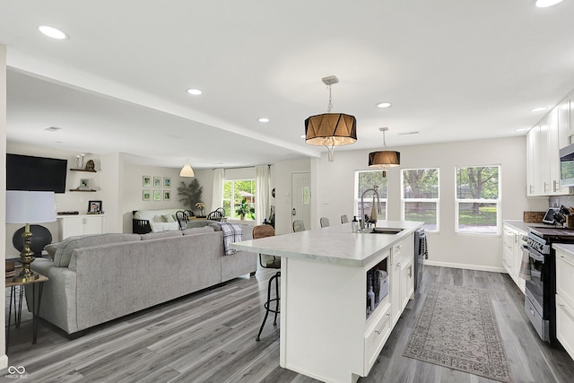 4132 Tincher Rd, Indianapolis, IN 46221 - kitchen featuring appliances with stainless steel finishes, a kitchen bar, white cabinets, light countertops, and dark wood-type flooring