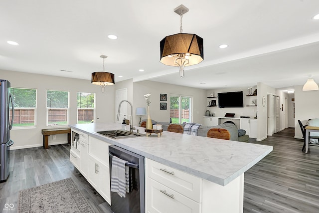 4132 Tincher Rd, Indianapolis, IN 46221 - kitchen featuring white cabinets, appliances with stainless steel finishes, light wood-style floors, a center island with sink, and hanging light fixtures