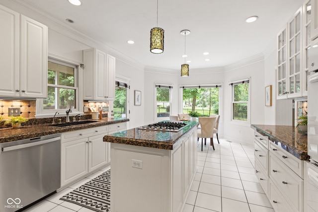11266 Old Stone Dr, Indianapolis, IN 46236 - kitchen with stainless steel appliances, light tile patterned floors, plenty of natural light, tasteful backsplash, and ornamental molding