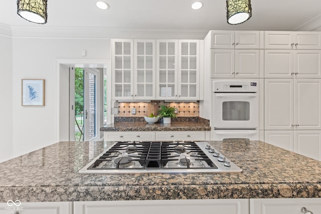 11266 Old Stone Dr, Indianapolis, IN 46236 - kitchen featuring stainless steel gas cooktop, white cabinets, glass insert cabinets, crown molding, and dark countertops