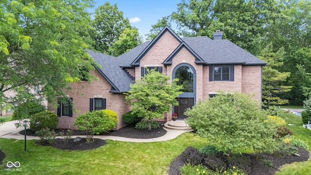 11266 Old Stone Dr, Indianapolis, IN 46236 - traditional-style house with brick siding, a chimney, roof with shingles, and a front lawn