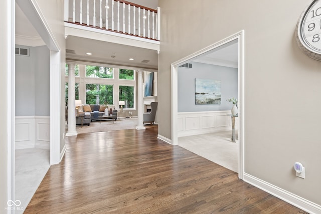 11266 Old Stone Dr, Indianapolis, IN 46236 - foyer entrance featuring a decorative wall, wood finished floors, decorative columns, a wainscoted wall, and crown molding