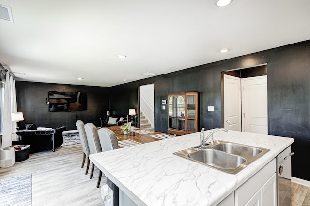 6332 Card Blvd, Indianapolis, IN 46221 - kitchen with light wood-style flooring, dishwasher, open floor plan, white cabinetry, and a kitchen island with sink