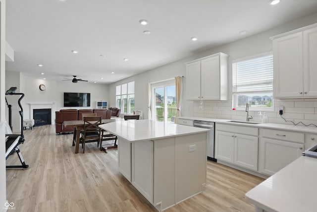 633 Cowley Dr, Westfield, IN 46074 - kitchen with dishwasher, decorative backsplash, white cabinets, a kitchen island, and a fireplace