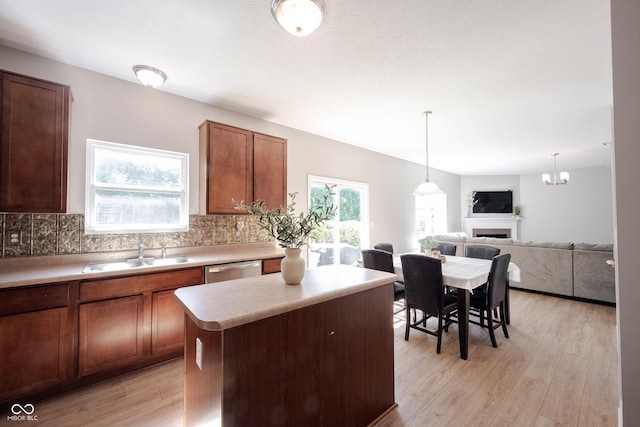13829 Black Canyon Ct, Fishers, IN 46038 - kitchen with light wood-type flooring, tasteful backsplash, a fireplace, and light countertops