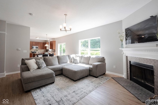13829 Black Canyon Ct, Fishers, IN 46038 - living room featuring a chandelier, light wood-style floors, and a tiled fireplace