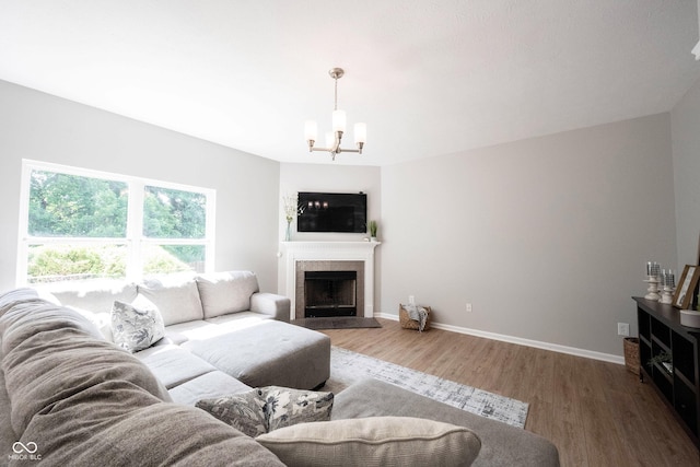 13829 Black Canyon Ct, Fishers, IN 46038 - living room with a chandelier, wood finished floors, and a tile fireplace