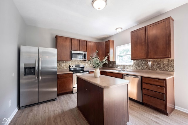 13829 Black Canyon Ct, Fishers, IN 46038 - kitchen with appliances with stainless steel finishes, tasteful backsplash, light wood finished floors, light countertops, and a kitchen island
