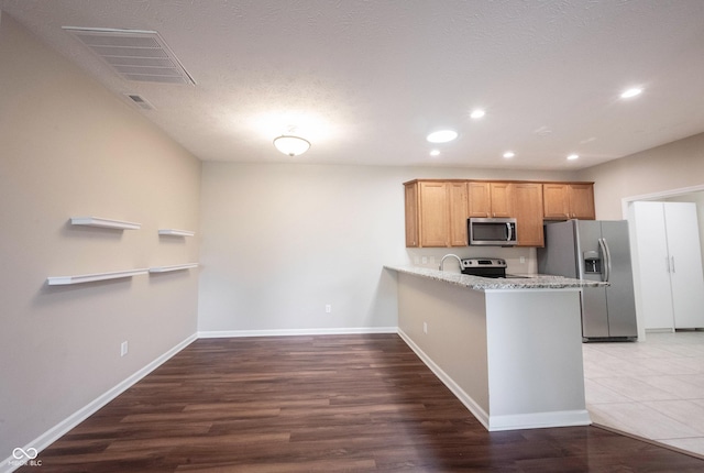 6586 Quail Run, Fishers, IN 46038 - kitchen featuring stainless steel appliances, recessed lighting, a peninsula, dark wood-style flooring, and light stone countertops