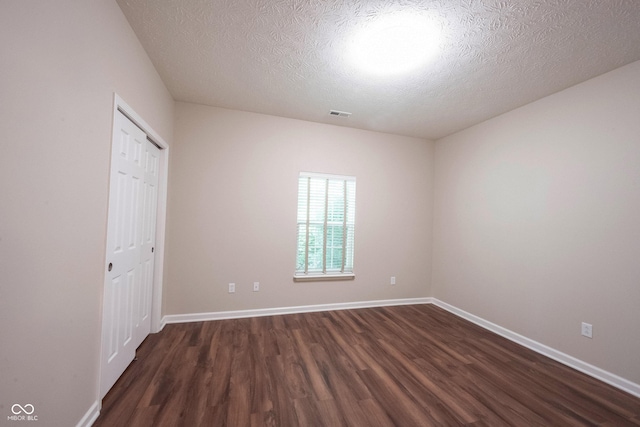 6586 Quail Run, Fishers, IN 46038 - unfurnished bedroom with dark wood-style floors, a textured ceiling, and a closet