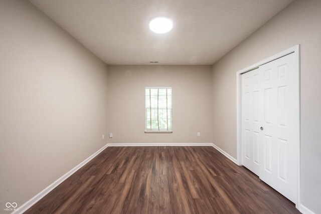 6586 Quail Run, Fishers, IN 46038 - unfurnished bedroom with dark wood-style flooring and a closet