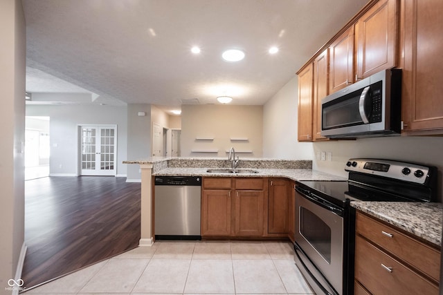 6586 Quail Run, Fishers, IN 46038 - kitchen featuring appliances with stainless steel finishes, open floor plan, a peninsula, brown cabinets, and recessed lighting