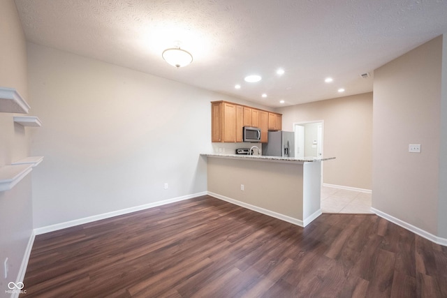 6586 Quail Run, Fishers, IN 46038 - kitchen featuring stainless steel appliances, dark wood-style flooring, a peninsula, recessed lighting, and light stone countertops