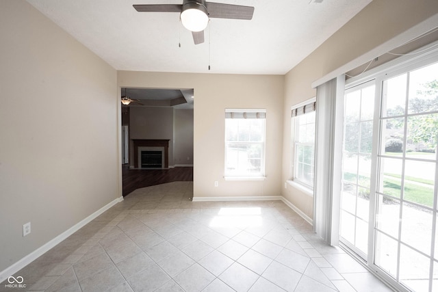 6586 Quail Run, Fishers, IN 46038 - unfurnished room with a ceiling fan, healthy amount of natural light, light tile patterned floors, and a fireplace