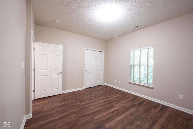 6586 Quail Run, Fishers, IN 46038 - unfurnished bedroom featuring dark wood-type flooring, a textured ceiling, and a closet