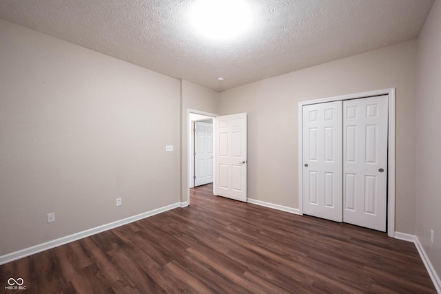 6586 Quail Run, Fishers, IN 46038 - unfurnished bedroom featuring dark wood finished floors, a textured ceiling, and a closet