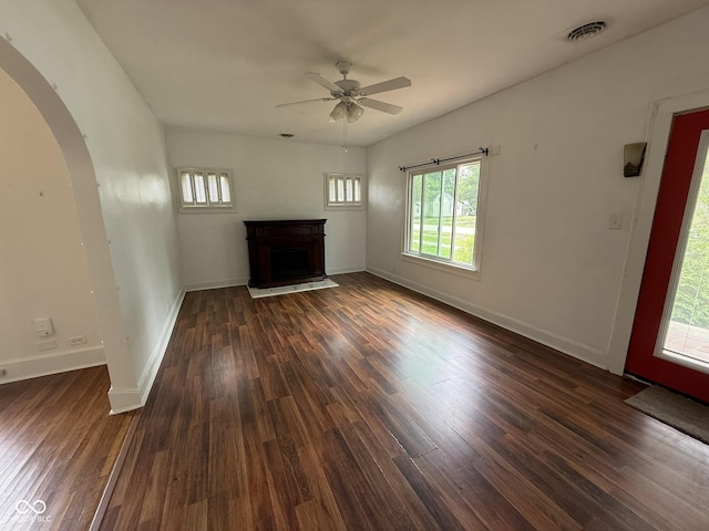 140 N Sycamore St, Dana, IN 47847 - unfurnished living room featuring arched walkways, a ceiling fan, a fireplace, and dark wood finished floors