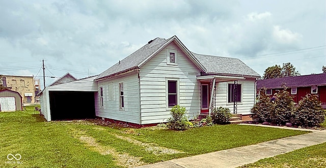 140 N Sycamore St, Dana, IN 47847 - view of front of home featuring a front lawn, roof with shingles, and a shed