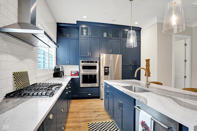 906 Berkhamsted Ln, Carmel, IN 46032 - kitchen featuring wall chimney range hood, stainless steel appliances, blue cabinets, decorative backsplash, and light stone counters