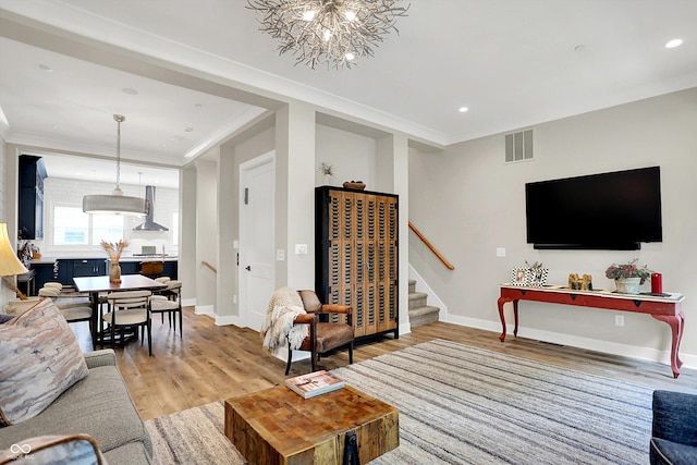 906 Berkhamsted Ln, Carmel, IN 46032 - living room with stairs, light wood-type flooring, a chandelier, recessed lighting, and ornamental molding