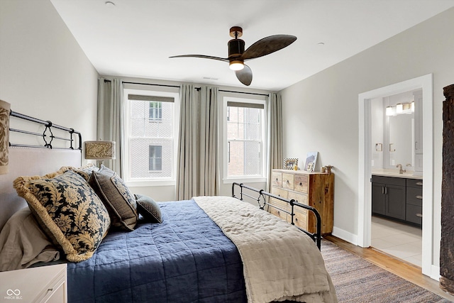 906 Berkhamsted Ln, Carmel, IN 46032 - bedroom with light wood finished floors, connected bathroom, and ceiling fan