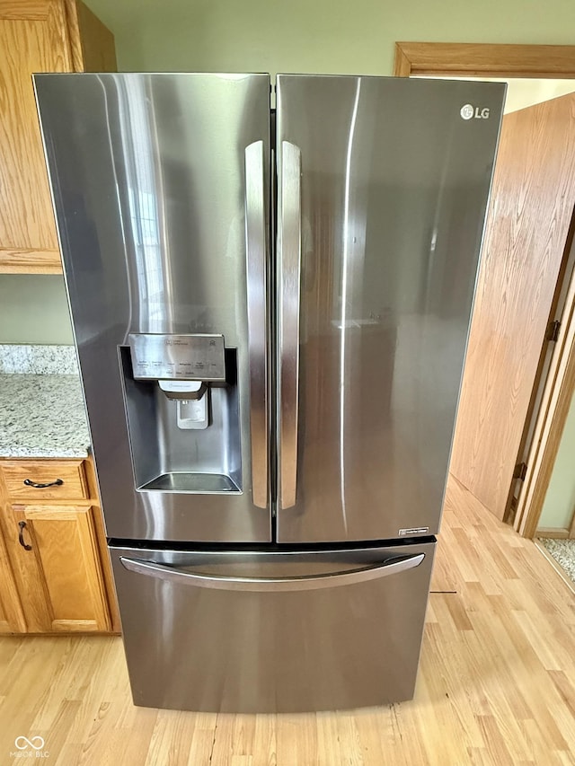 1687 Killion Ave, Seymour, IN 47274 - kitchen view of stainless steel fridge with ice dispenser, light wood-style floors, and light stone counters