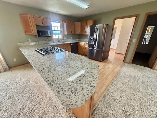 1687 Killion Ave, Seymour, IN 47274 - kitchen with appliances with stainless steel finishes, a peninsula, brown cabinets, light wood finished floors, and light stone countertops
