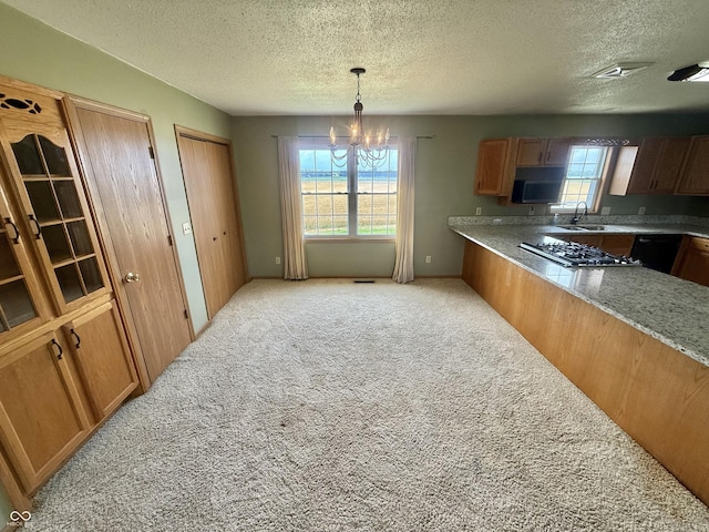 1687 Killion Ave, Seymour, IN 47274 - kitchen with a chandelier, stainless steel gas cooktop, a textured ceiling, light colored carpet, and brown cabinetry