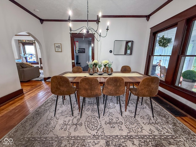 251 N St, Danville, IN 46122 - dining area with wood finished floors, arched walkways, ornamental molding, healthy amount of natural light, and a chandelier