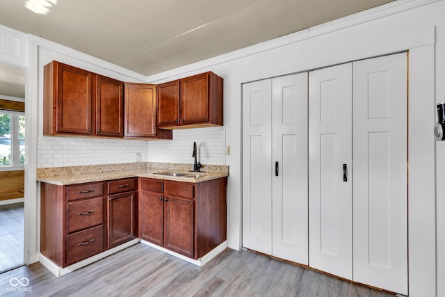 917 W Busby St, Lebanon, IN 46052 - kitchen with light wood-type flooring, decorative backsplash, light stone counters, and brown cabinets