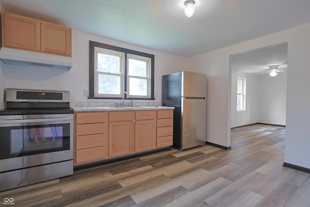 523 Patterson Rd, Columbus, IN 47203 - kitchen featuring appliances with stainless steel finishes, under cabinet range hood, light brown cabinetry, light countertops, and plenty of natural light