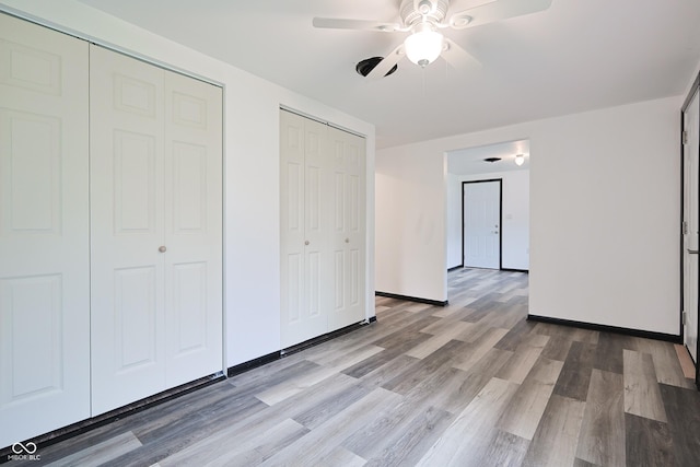 523 Patterson Rd, Columbus, IN 47203 - unfurnished bedroom featuring two closets, wood finished floors, and ceiling fan
