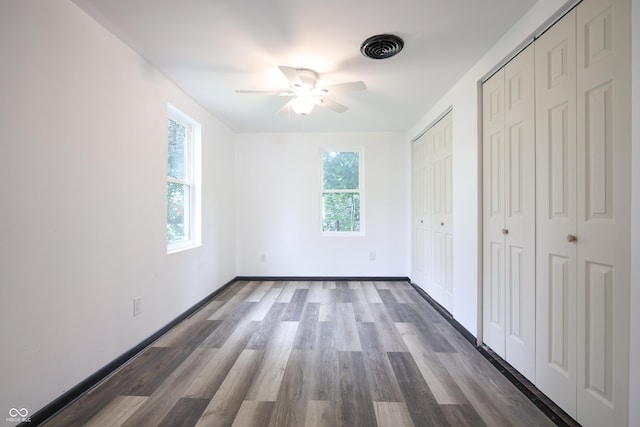 523 Patterson Rd, Columbus, IN 47203 - unfurnished bedroom featuring multiple closets, wood finished floors, and ceiling fan