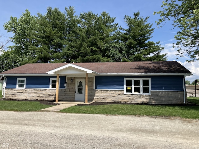 321 S 23rd St, Elwood, IN 46036 - ranch-style home with stone siding, a shingled roof, and a front yard