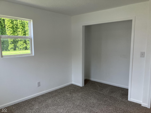 321 S 23rd St, Elwood, IN 46036 - unfurnished bedroom with dark colored carpet and baseboards