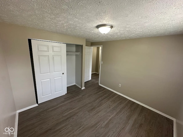 10316 Woodhaven Cir, Indianapolis, IN 46229 - unfurnished bedroom featuring dark wood-style floors, a textured ceiling, and a closet