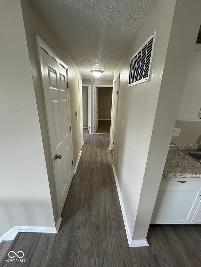 10316 Woodhaven Cir, Indianapolis, IN 46229 - corridor with dark wood-style floors and a textured ceiling