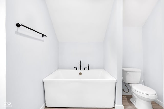 3035 Guilford Ave, Indianapolis, IN 46205 - full bath featuring a freestanding bath, vaulted ceiling, and wood finished floors