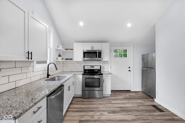 3035 Guilford Ave, Indianapolis, IN 46205 - kitchen featuring stainless steel appliances, open shelves, white cabinetry, backsplash, and lofted ceiling
