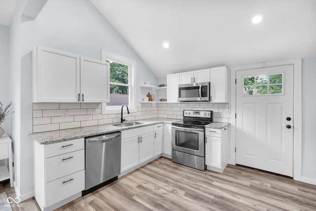 3035 Guilford Ave, Indianapolis, IN 46205 - kitchen with stainless steel appliances, white cabinets, vaulted ceiling, tasteful backsplash, and open shelves