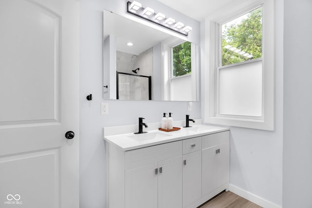 3035 Guilford Ave, Indianapolis, IN 46205 - bathroom with double vanity, a shower, and wood finished floors