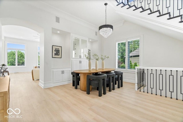 12208 Island Dr, Indianapolis, IN 46256 - dining room with light wood-type flooring, arched walkways, a chandelier, and lofted ceiling
