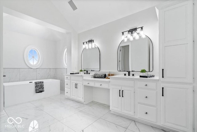12208 Island Dr, Indianapolis, IN 46256 - full bathroom featuring lofted ceiling, double vanity, a tub to relax in, and marble finish floors