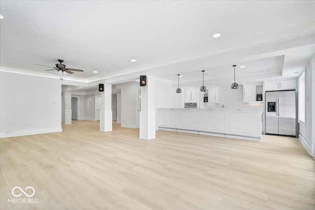 12208 Island Dr, Indianapolis, IN 46256 - unfurnished living room featuring light wood finished floors, ceiling fan, recessed lighting, crown molding, and a tray ceiling