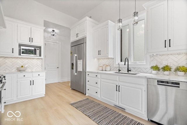 12208 Island Dr, Indianapolis, IN 46256 - kitchen featuring stainless steel appliances, backsplash, white cabinets, and light wood-type flooring