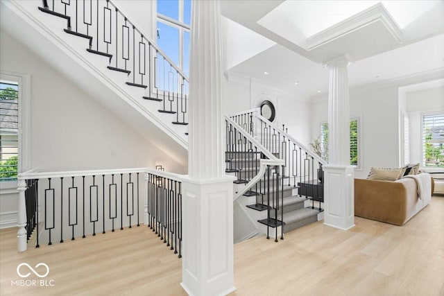 12208 Island Dr, Indianapolis, IN 46256 - staircase featuring wood finished floors, ornate columns, and a towering ceiling