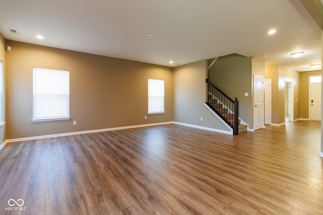 6610 Aberdeen Dr, Mccordsville, IN 46055 - unfurnished living room featuring stairway, wood finished floors, plenty of natural light, and recessed lighting