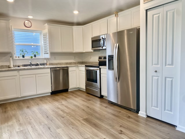213 Drewood Dr, Trafalgar, IN 46181 - kitchen with stainless steel appliances, white cabinetry, light wood-type flooring, recessed lighting, and light stone counters