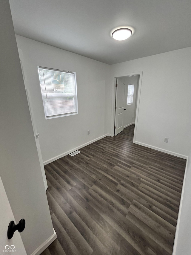 3201 W 22nd St, Indianapolis, IN 46222 - empty room featuring healthy amount of natural light and dark wood finished floors