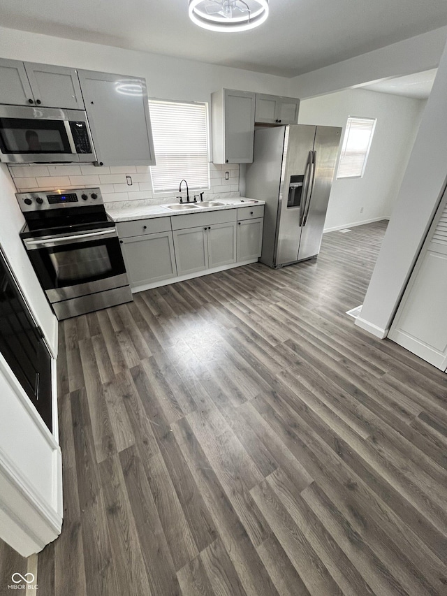 3201 W 22nd St, Indianapolis, IN 46222 - kitchen featuring appliances with stainless steel finishes, gray cabinets, light countertops, and dark wood finished floors